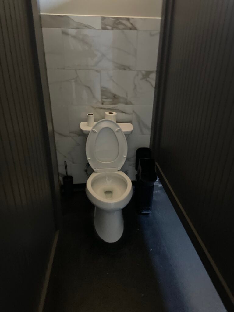 Commercial restroom plumbing work during a toilet replacement at Bambino’s Burgers in New Iberia