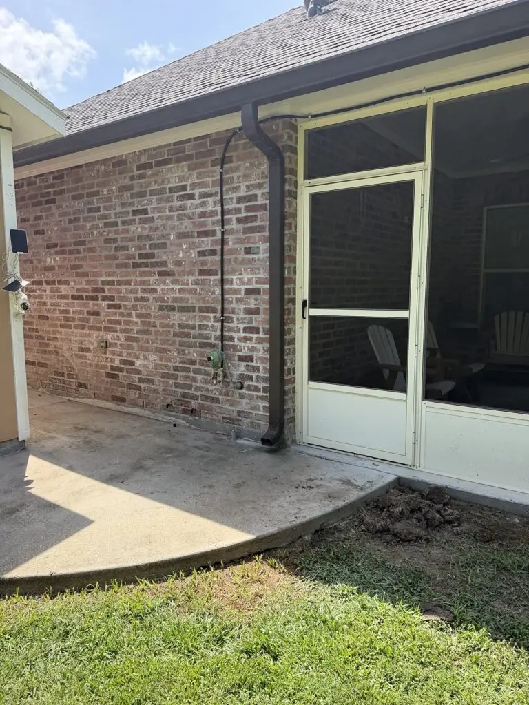 Technician positioning an exterior gas line riser beside a residential building in Breaux Bridge, Louisiana