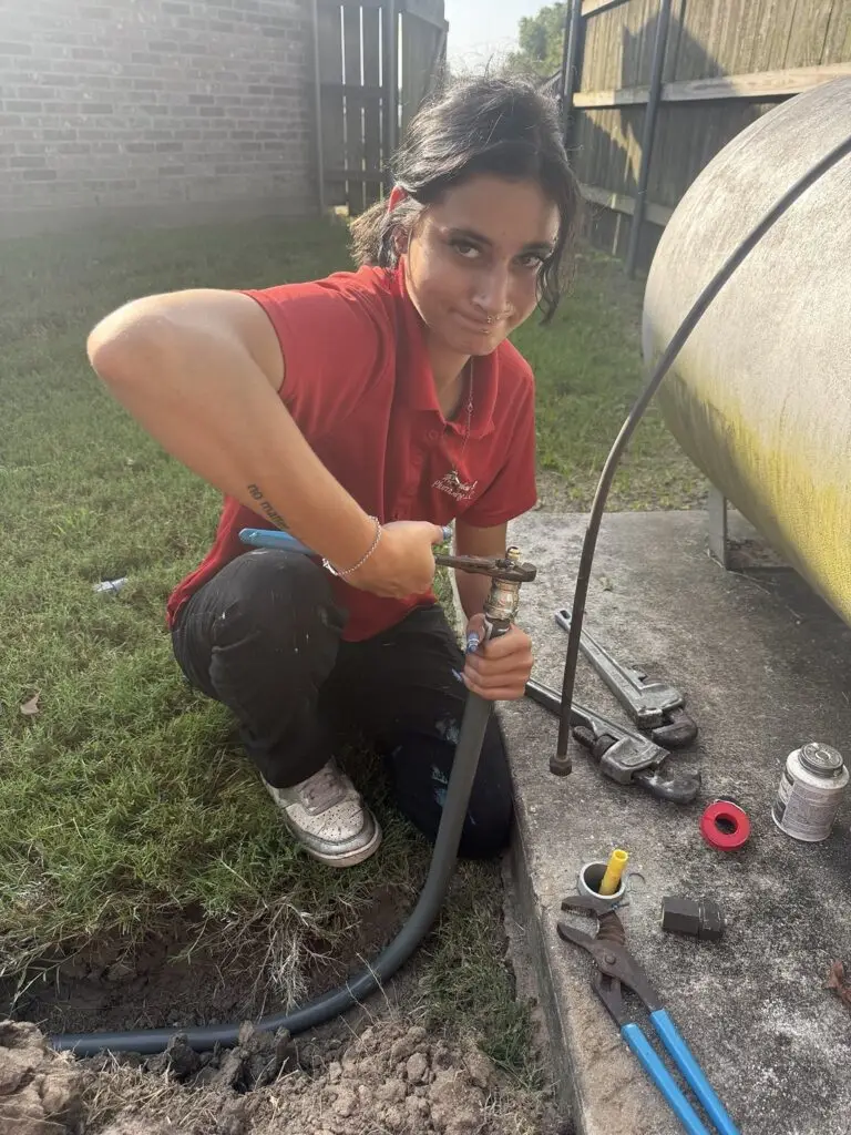 Technician tightening a new propane gas line connection during replacement work in Breaux Bridge, Louisiana