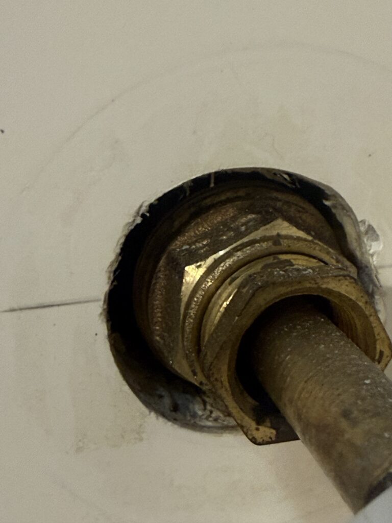 Close-up of the worn three-handle tub and shower faucet valve before replacement in New Iberia, Louisiana