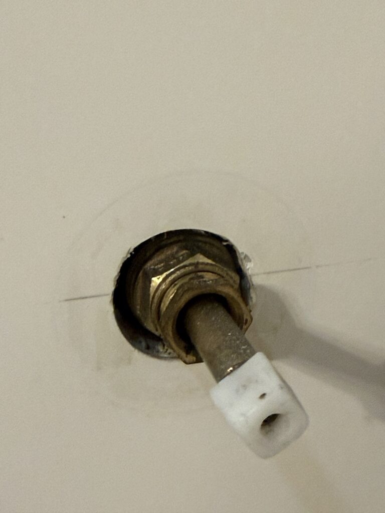 Worn valve stem on an older three-handle tub and shower faucet before conversion