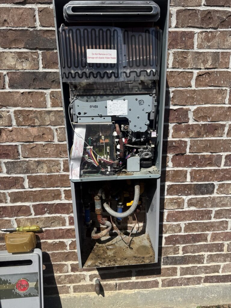 Older outdoor Rheem tankless water heater opened for replacement in Lafayette, Louisiana
