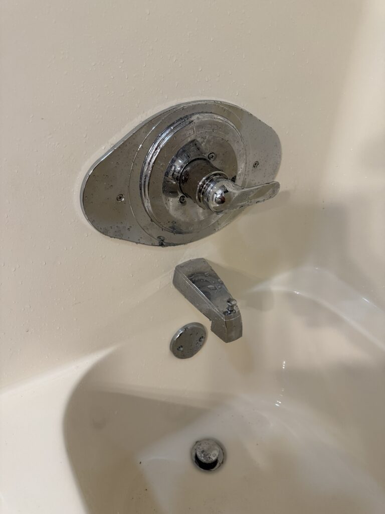 Close-up of the finished Delta single-handle tub and shower faucet with chrome renovation plate